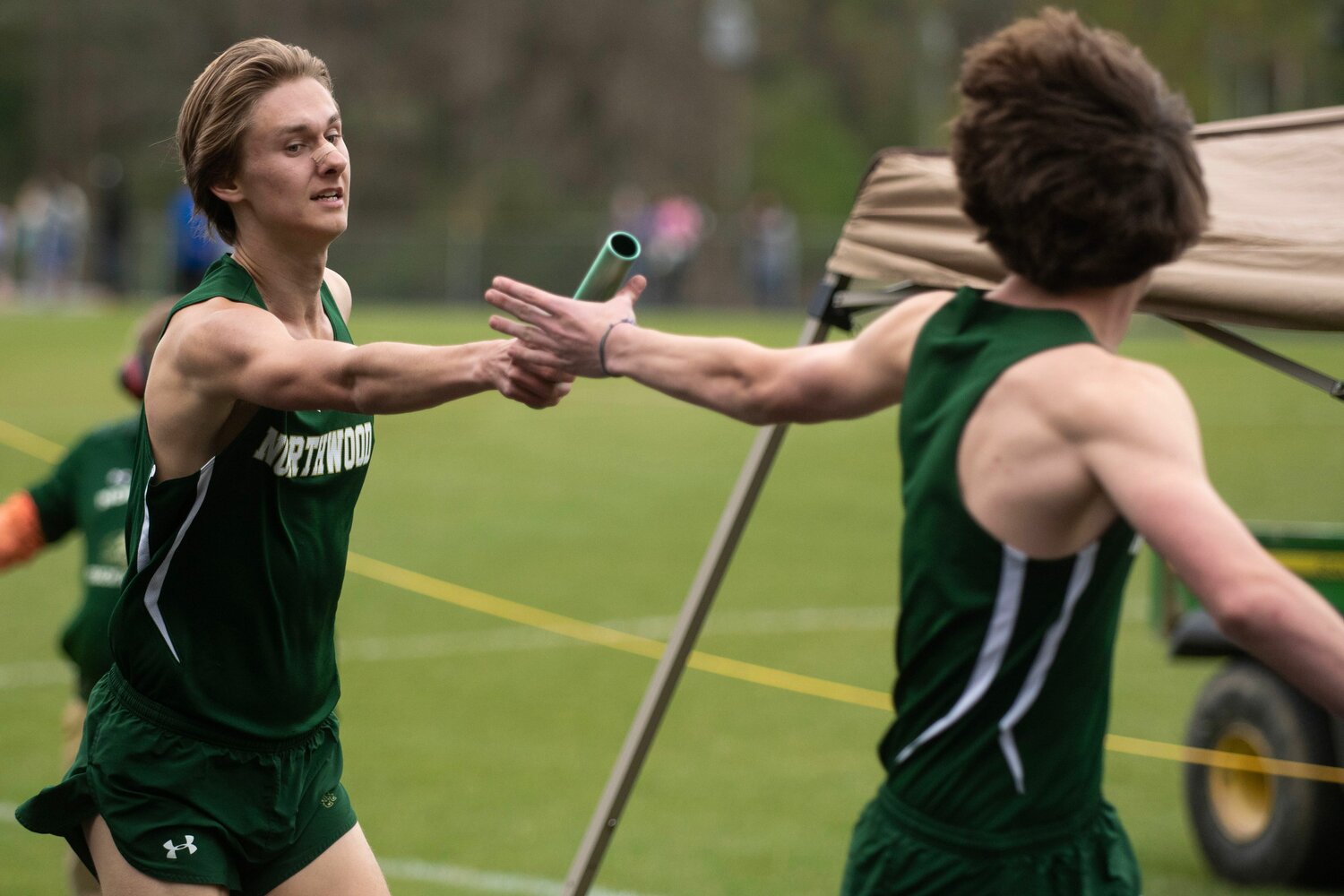 Northwood's Jackson Adams (left) hands the baton to his teammate during a relay event at the Chatham County track and field championships.